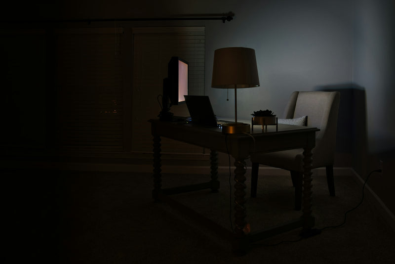 Desk with a lamp and a laptop casting warm focused light
