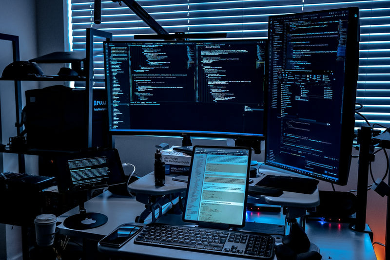 Desk with several monitors arranged in a multi screen workspace