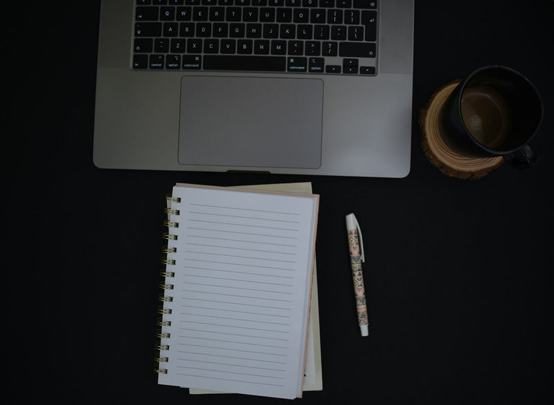 Open notebook and pen resting on a clean desk surface