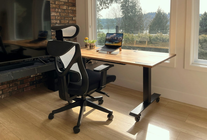 Calm home desk with a laptop set in front of a bright window