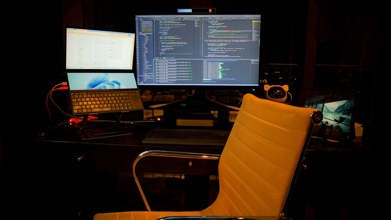 Computer desk with two monitors and a laptop in a clean workspace