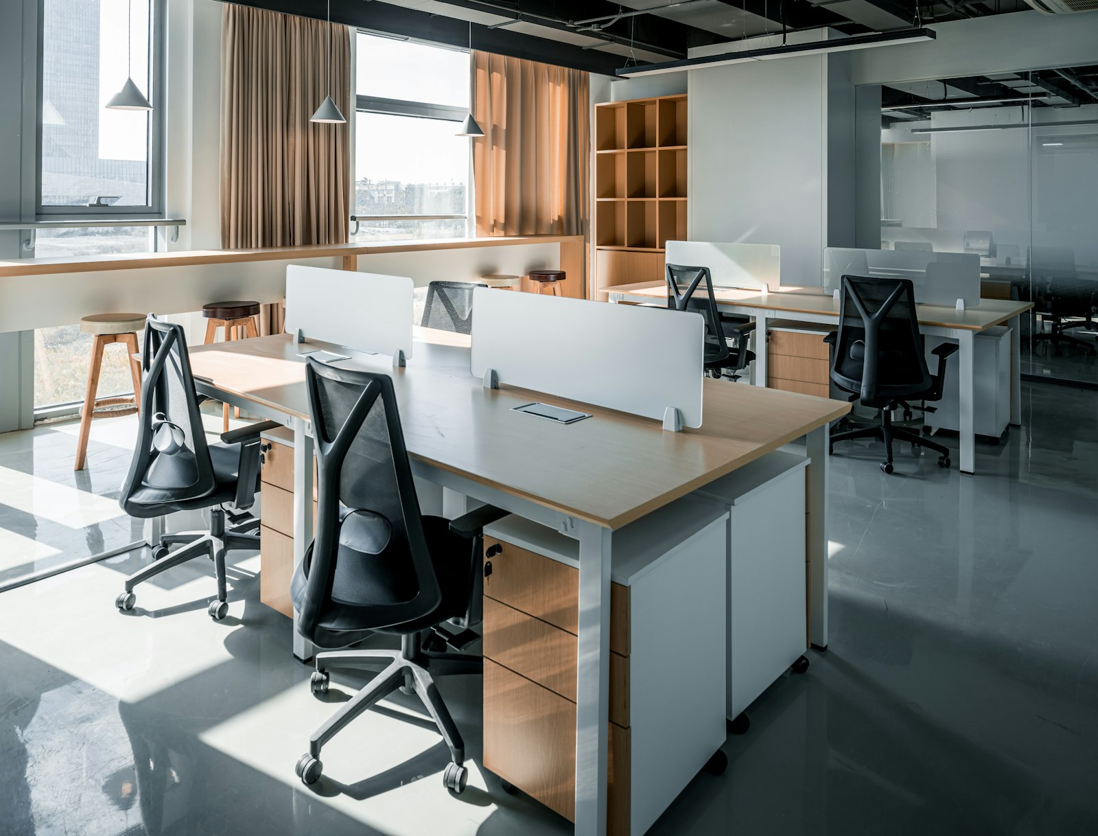 Office with a desk and chairs beside a window in bright daylight