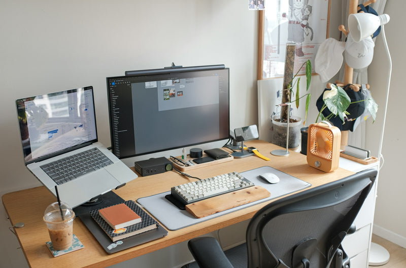 Desk with a laptop and a computer monitor in a tidy workspace