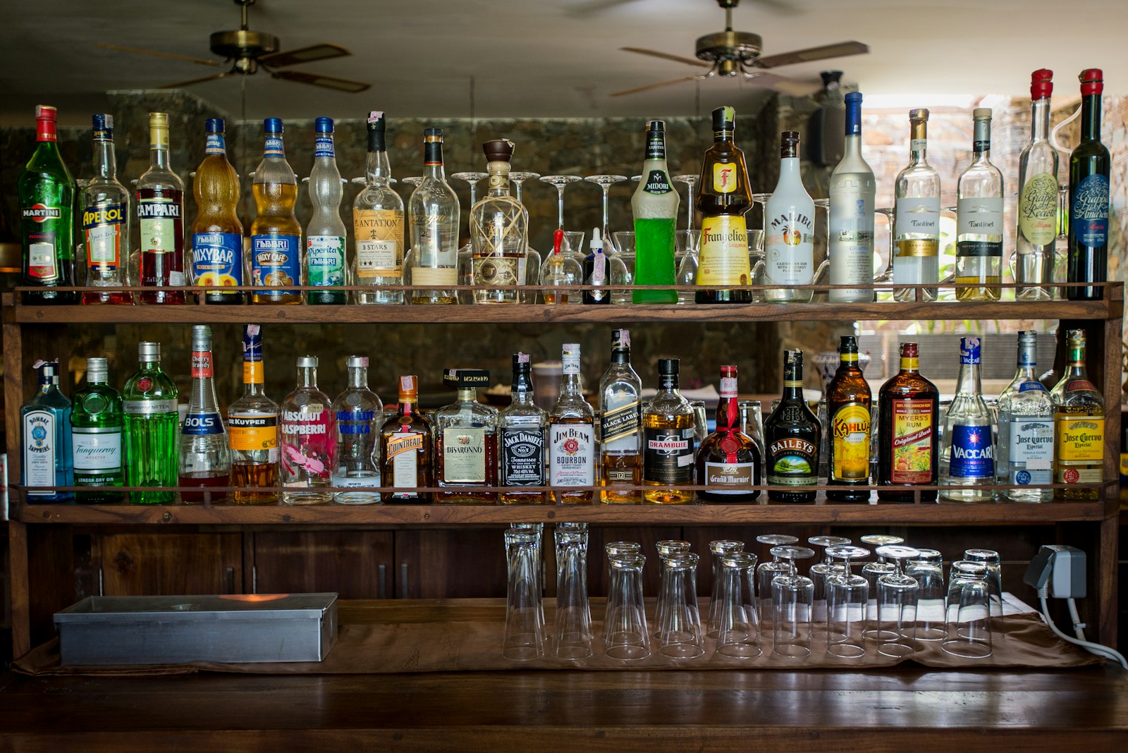 Refined bar with neatly arranged bottles and glassware in warm light