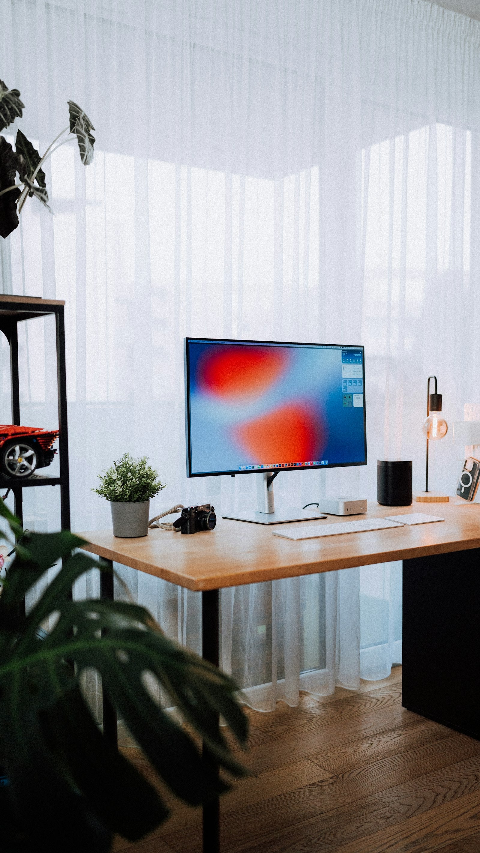 A cozy home office with a modern desk setup and warm light