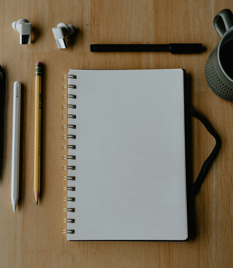 Clean workspace with a notepad, pen, and minimal desk accessories
