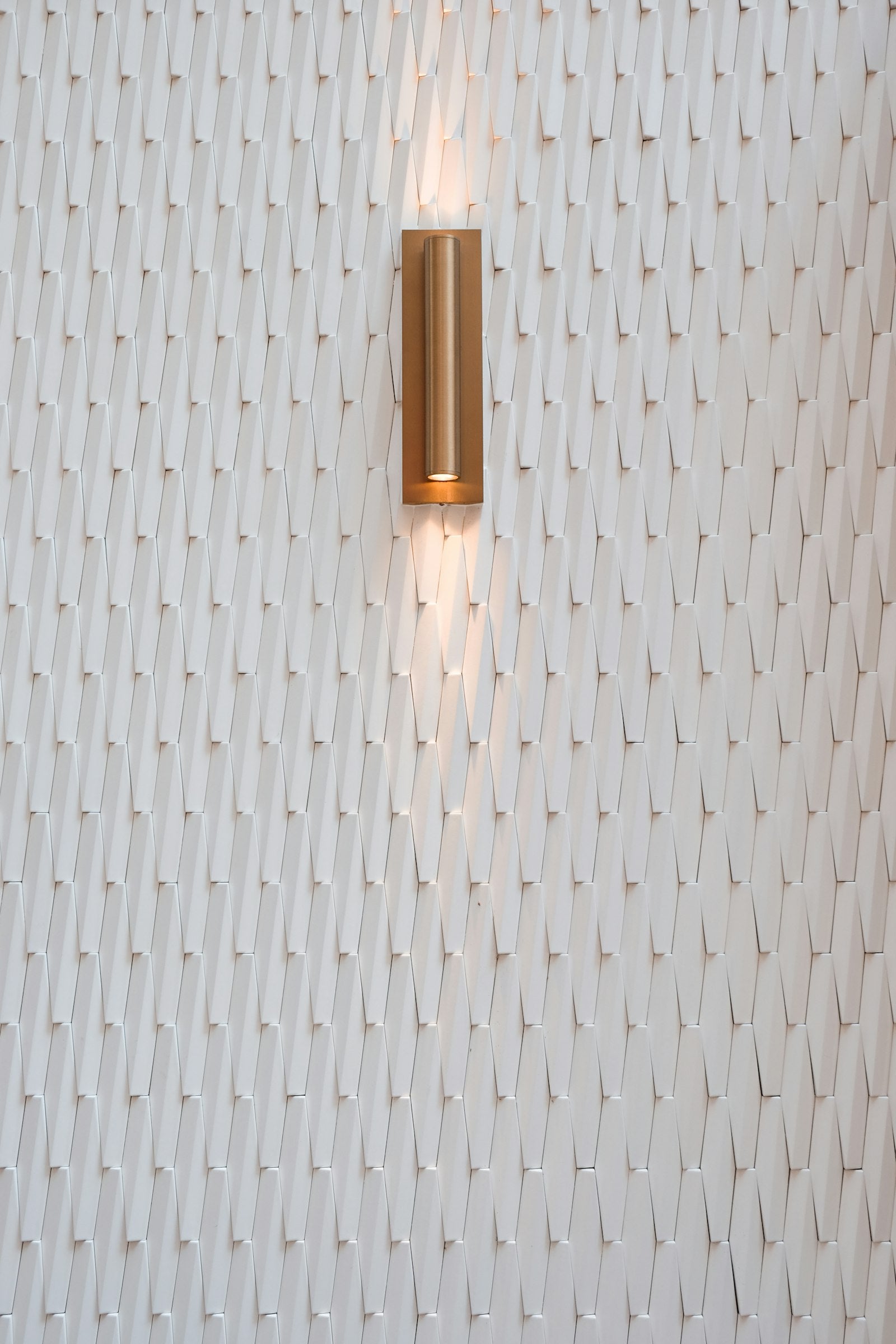 Modern wall sconce casting soft light across a textured wall