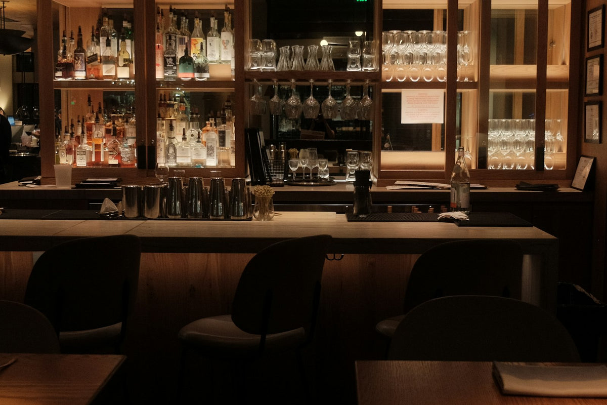 Refined home bar with bottles and glassware arranged on shelves under soft light
