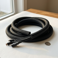 Woven black cable sleeve coiled with several cables entering one open end, showing the self-wrap split seam