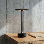 Halo Cordless Table Lamp in Black on a concrete-and-oak desk