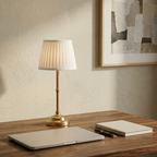 Cordless Pleated-Shade Table Lamp on a home office desk beside a laptop